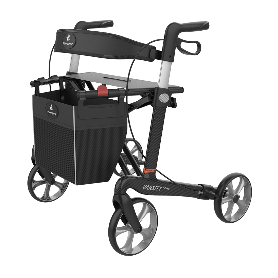 The Rehasense Varsity CF HD Bariatric Lightweight Rollator is a modern black and gray walker with four large wheels, a padded seat, handlebars with brakes, and a detachable front storage basket.
